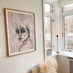 indrammet-maleri-paa-vaeg-abstrakt-portraetmaleri-af-sort-haaret-kvinde-i-lyse-toner