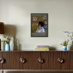 the-antagonist-reklame-plakat-solo-udstilling-paa-vaeggen-over-brun-kommode