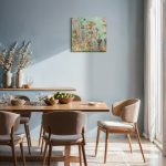 Maleri af blomsterhave med orange, lilla og violette blomster og varmblå himmel. Original. Hængende i en stue på en blåfarvet væg.