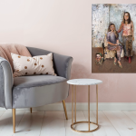 Familieportræt af tre generationer hvor datteren sidder i en lænestol, mormor står bagved og søn ligger på gulvet